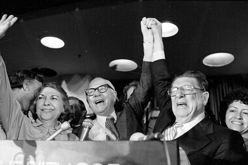 Paul Gann, left, and Howard Jarvis hold up their hands as their co-authored initiative Propsition 13 takes a commanding lead in the California primary, in Los Angeles, June 7, 1978. (Photo by AP Photo)