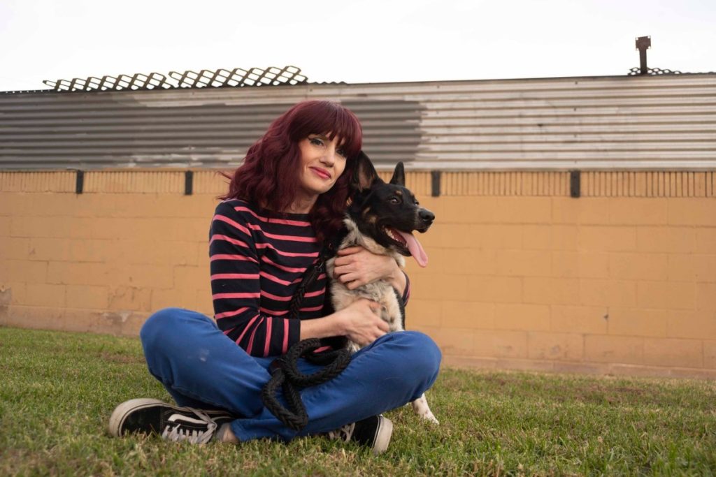 Stephanie Moore sits with her eight-month-old dog Spooky. (Photo by Tash Kimmell for CalMatters)