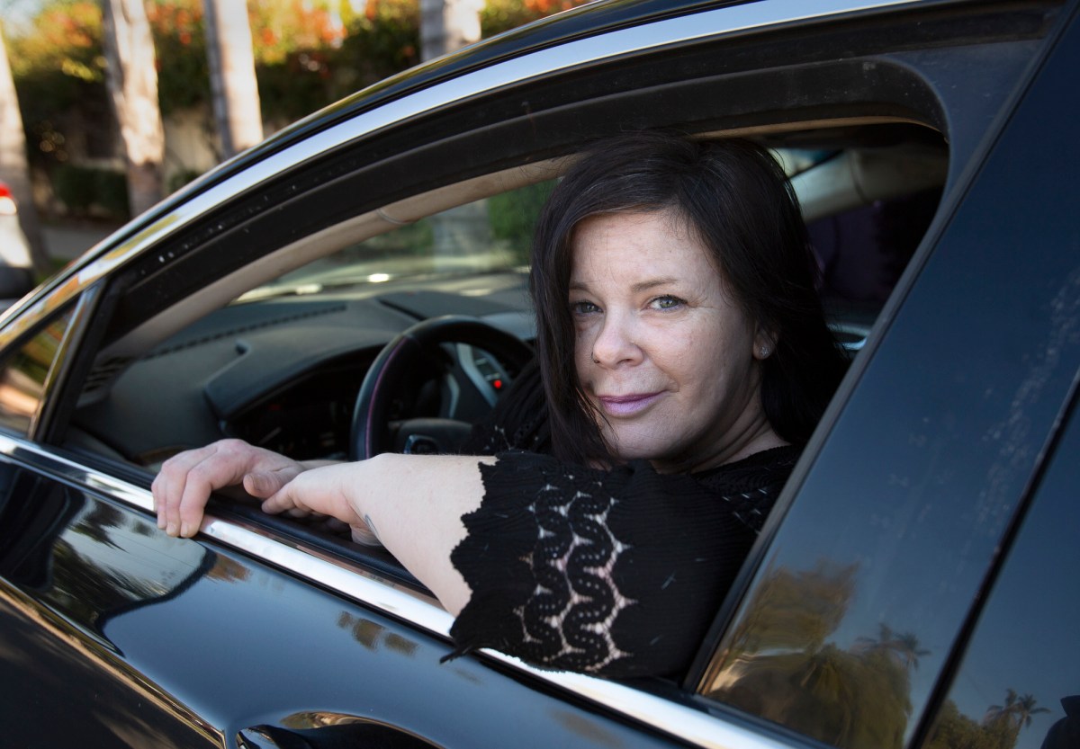 Erica Wood is photographed in her car near her home in San Diego on Feb. 6, 2021. Wood owns a small mobile piercing business. While struggling with unemployment benefits, she took out a title loan on her car and is now in debt as a result. (Photo by Peggy Peattie for CalMatters)