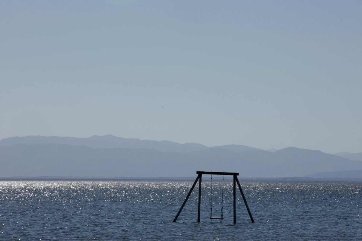 A swing set stands alone in the Salton Sea. State officials are helping fund experimental projects to extract valuable lithium from the lake’s brine. (Photo by Shae Hammond for CalMatters)