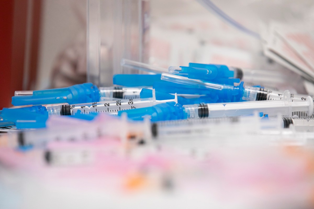 Health workers prepare different sized syringes with the Moderna COVID-19 vaccine. (Photo by Anne Wernikoff, CalMatters)