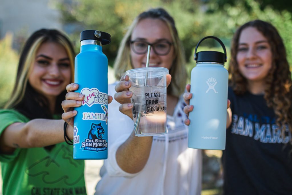 Students showing off their sustainable drinking containers before the pandemic.