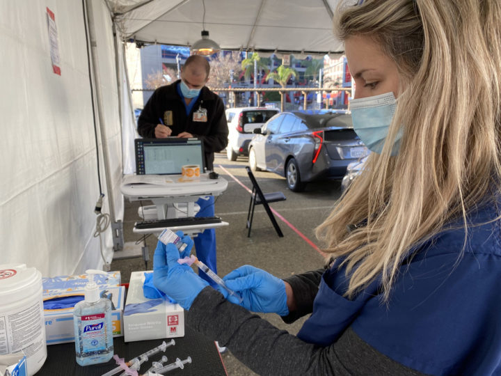 A nurse prepares a COVID-19 vaccine to be administered at Petco Park.